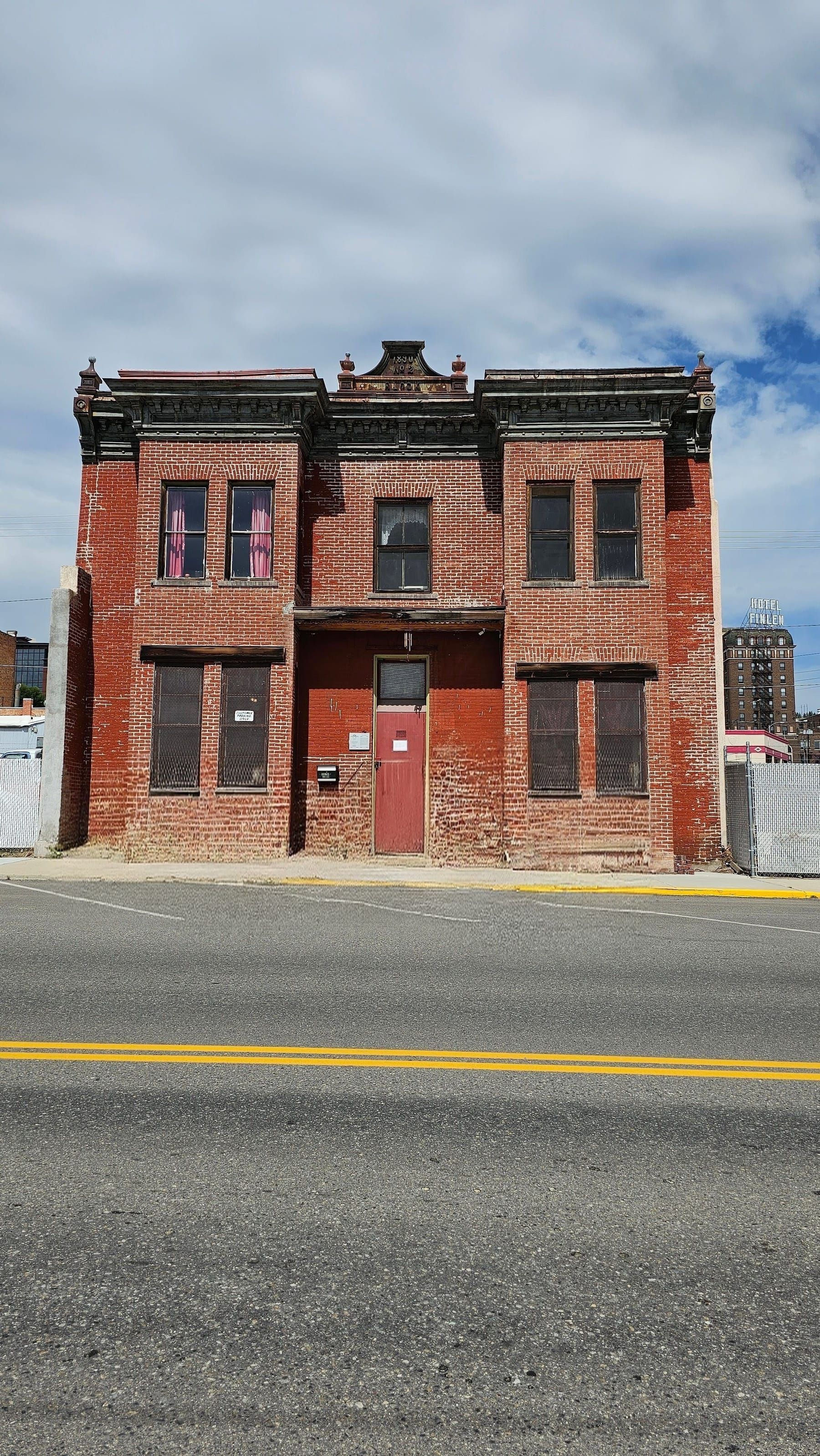A historic 1890 red-brick building on the line in Uptown Butte, daylight
